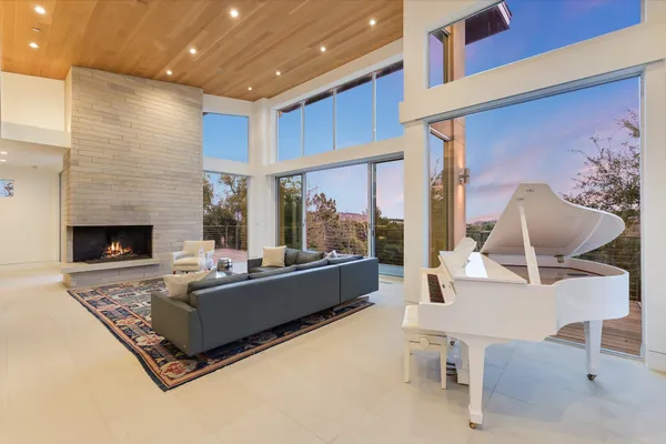 a living room with furniture fireplace and a large window