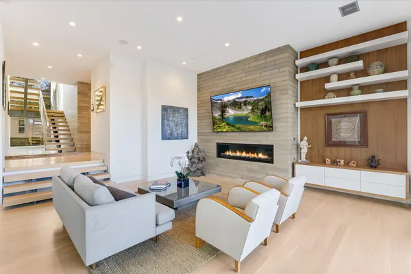 a living room with furniture fireplace and a large window
