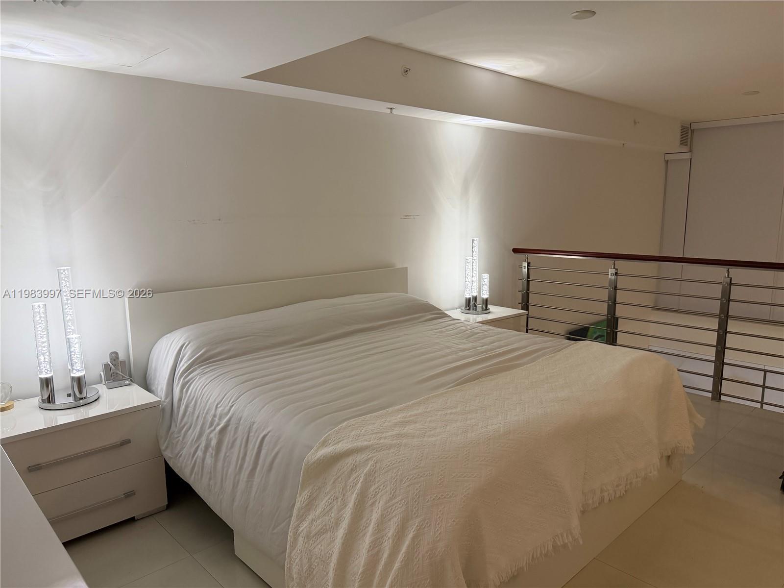 41 Southeast 5th Street, Unit 1106 Miami, FL 33131 - Photo 9 of 10 a bedroom with a bed and a night stand