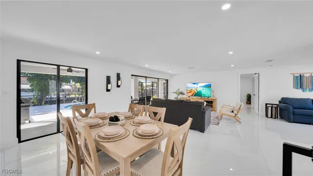 a living room with furniture a flat screen tv and a floor to ceiling window