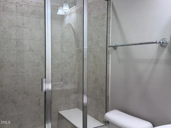 a bathroom with a sink double vanity granite toilet and a mirror