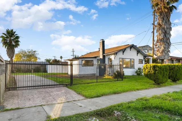 a view of a house next to a yard with big trees