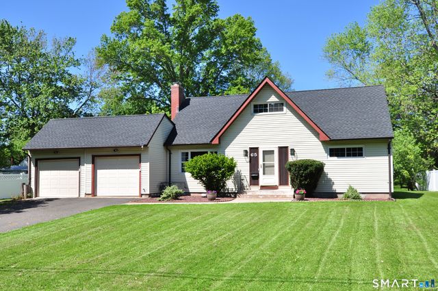 a front view of a house with a yard and trees