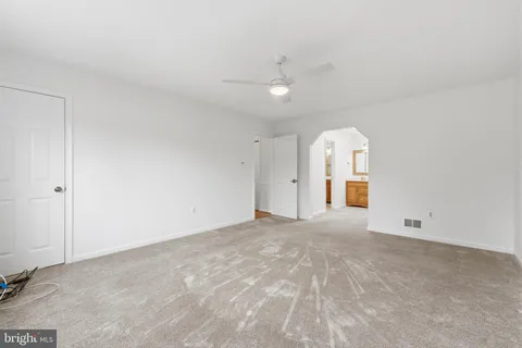 an empty room with a ceiling fan and window
