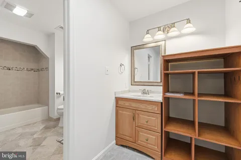a bathroom with a double vanity sink a toilet and shower