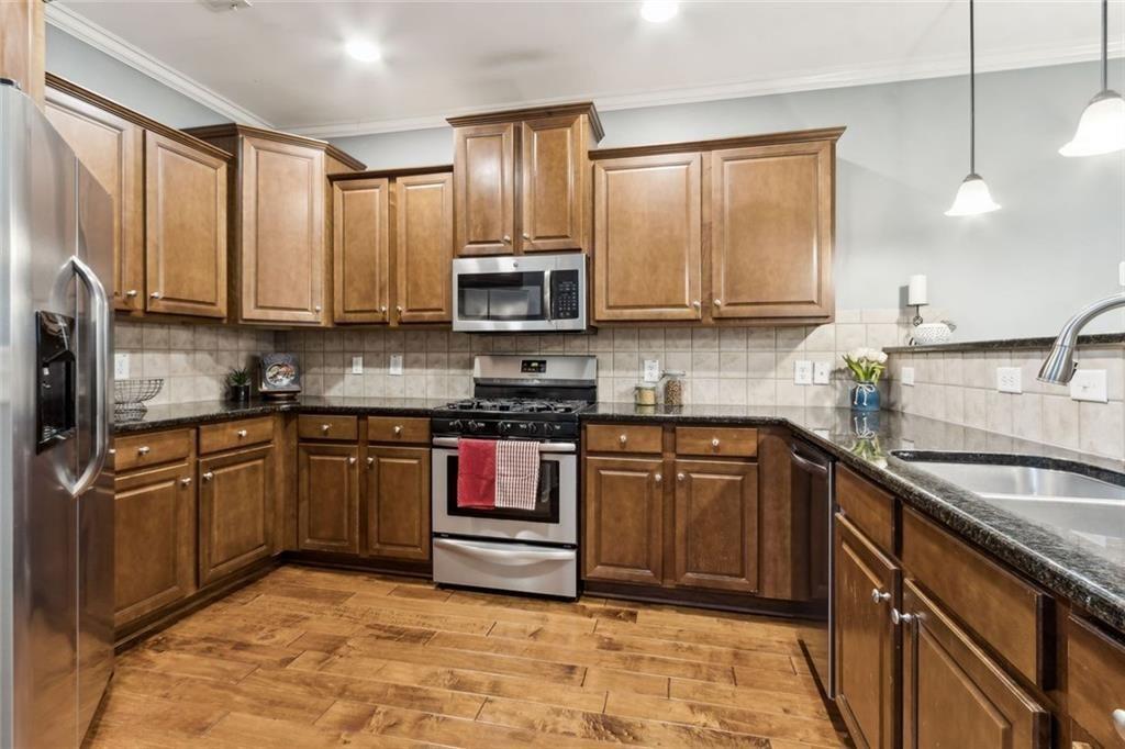 149 Trailside Circle Hiram, GA 30141 - Photo 13 of 35 a kitchen with stainless steel appliances granite countertop a sink stove and refrigerator