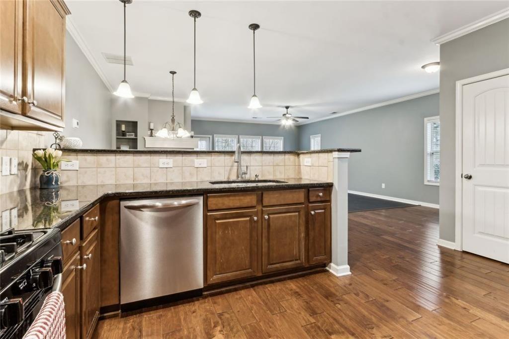 149 Trailside Circle Hiram, GA 30141 - Photo 14 of 35 a kitchen with stainless steel appliances granite countertop a sink a stove and a wooden floors