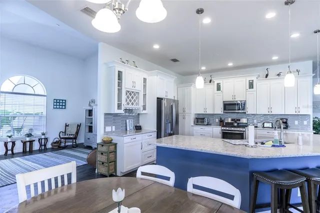 a bedroom with a bed a dresser and a large window