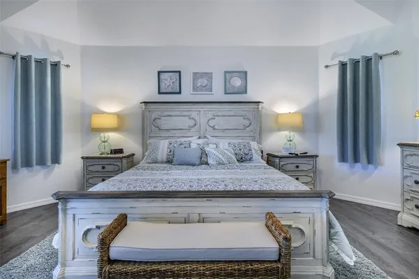 a bedroom with a bed and a potted plant on dresser