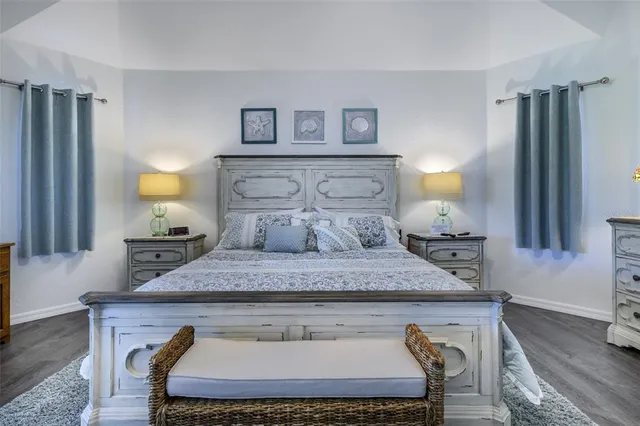 a bedroom with a bed and a potted plant on dresser