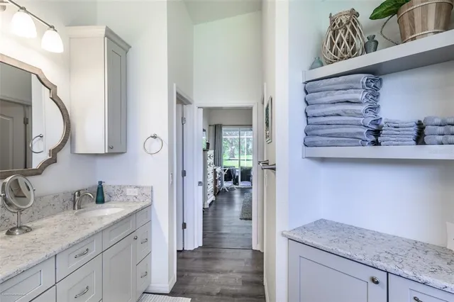 a bathroom with a granite countertop sink a mirror and shower