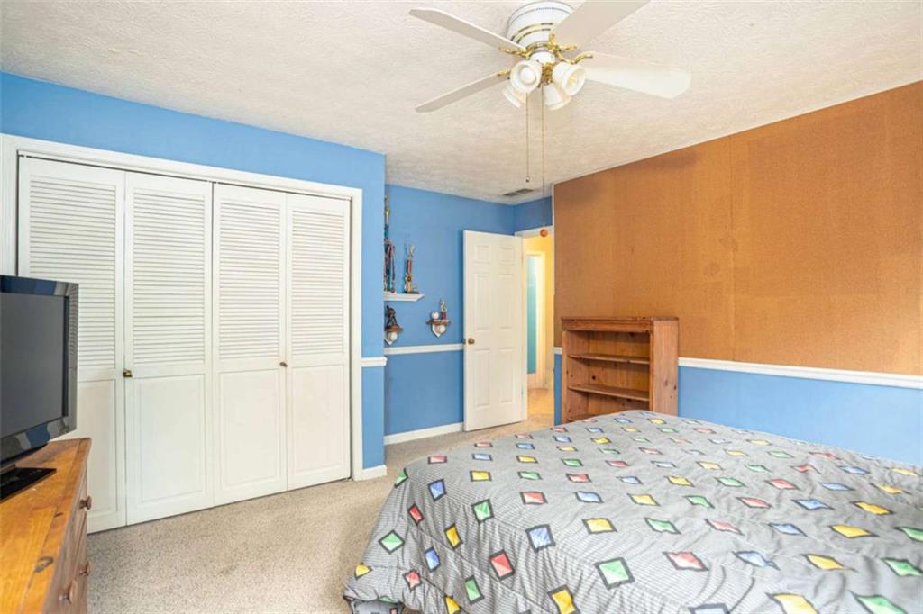 3838 Hunting Ridge Drive Southwest Lilburn, GA 30047 - Photo 33 of 56 a bedroom with a bed and a flat screen tv