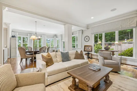 a dining hall with stainless steel appliances granite countertop wooden floor a dining table and chairs