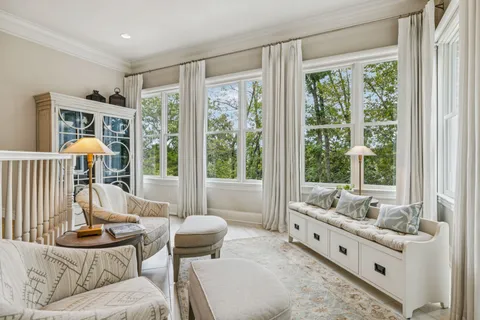 a large bed sitting in a bedroom next to a window and a chandelier