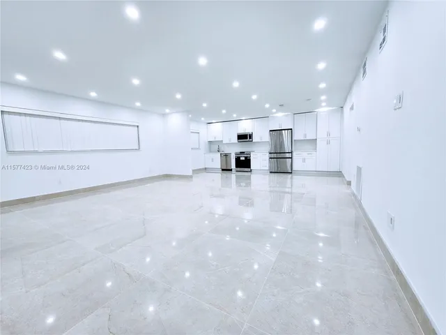 a view of kitchen with refrigerator and microwave