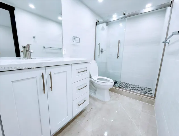 a bathroom with a granite countertop sink toilet and shower