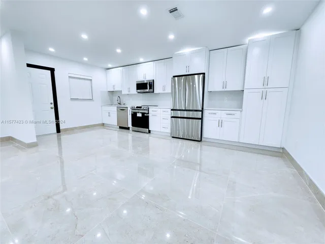 a kitchen with stainless steel appliances a refrigerator sink and microwave