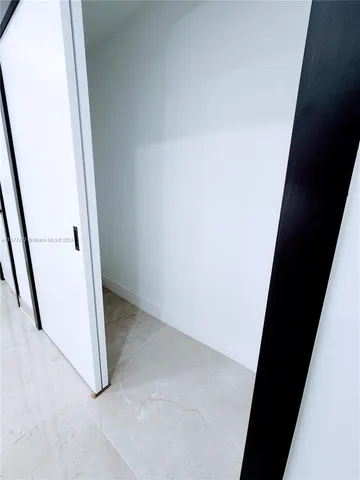 a view of a room with wooden floor and entryway