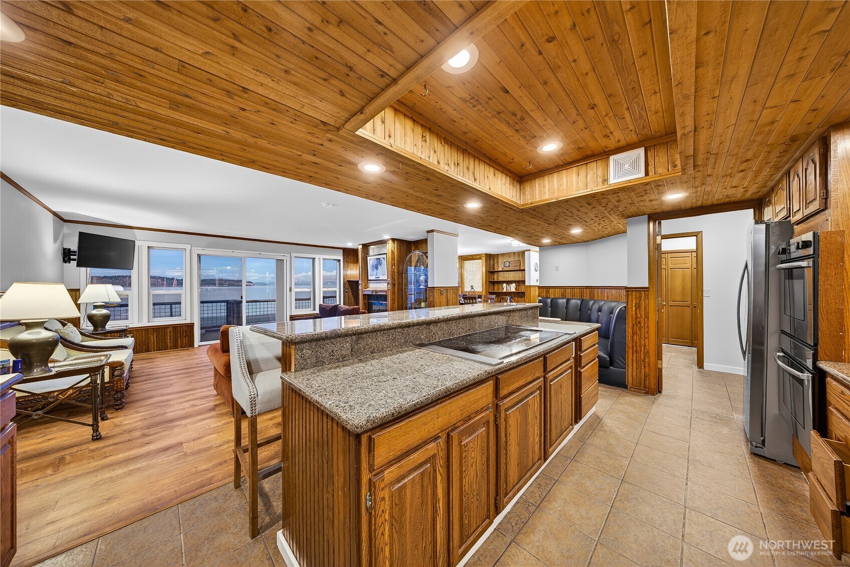 5972 Hastings Road Clinton, WA 98236 - Photo 30 of 40 a kitchen with stainless steel appliances granite countertop a table chairs and a refrigerator