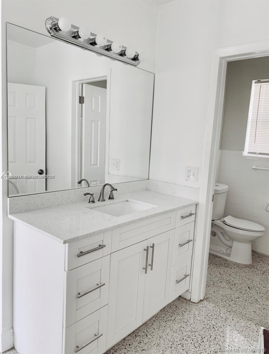 7731 Northwest 2nd Avenue, Unit 1 Miami, FL 33150 - Photo 4 of 7 a bathroom with a toilet sink and mirror