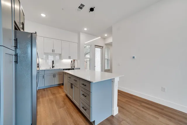 a kitchen with white cabinets and stainless steel appliances