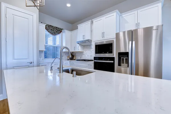 a kitchen with stainless steel appliances a refrigerator and a stove top oven