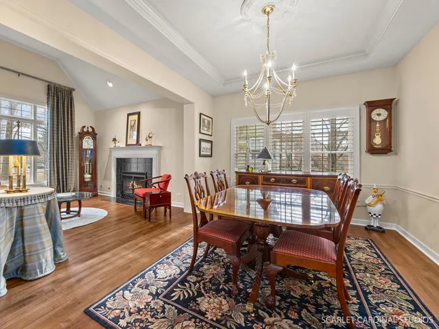 a dining room with furniture a chandelier and wooden floor