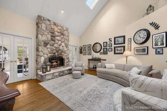 a living room with furniture a clock and a flat screen tv