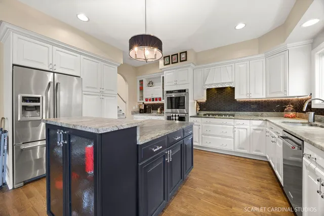 a kitchen with granite countertop stainless steel appliances a counter space cabinets and a sink