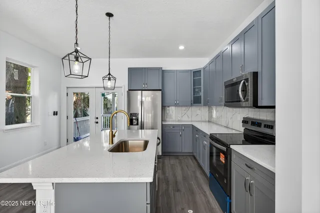 a kitchen with kitchen island a sink appliances and cabinets