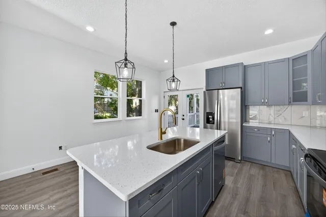 a kitchen with kitchen island a sink appliances and cabinets