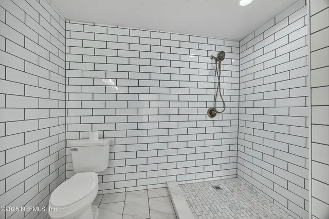 a bathroom with a toilet and a shower