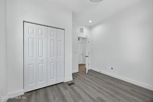 a view of an empty room with wooden floor
