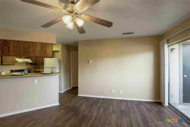 a view of a kitchen with a stove wooden floor and a kitchen space