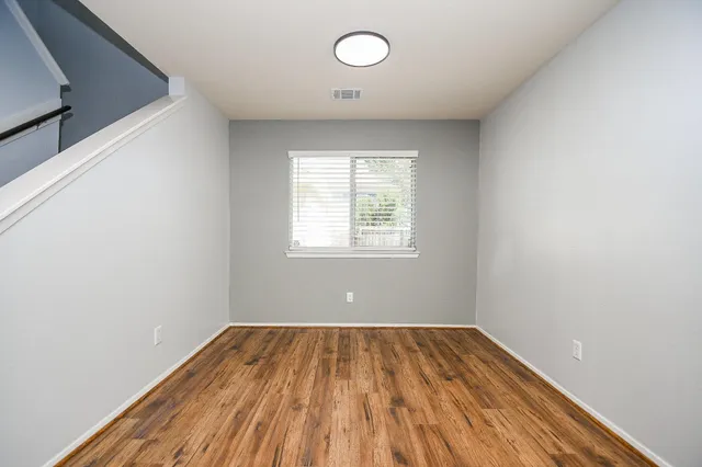 a view of a room with wooden floor and windows