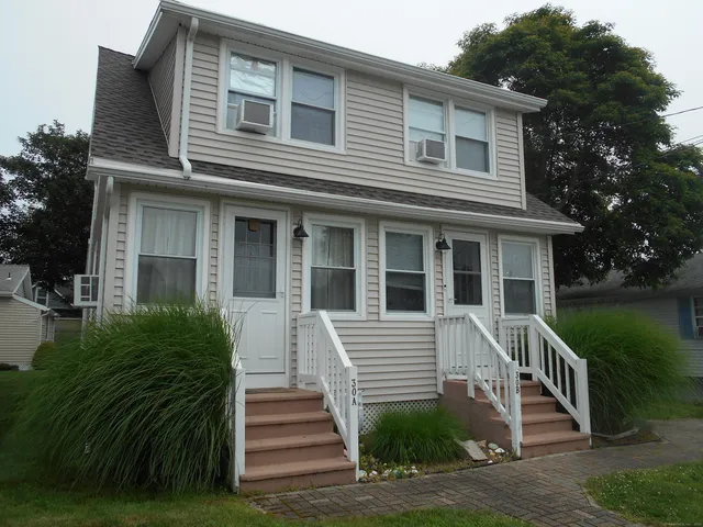 a view of a house with a yard and stairs