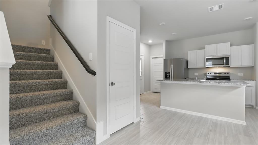 3149 Maple Orch Lane Fort Worth, TX 76140 - Photo 18 of 39 a kitchen with white cabinets and stainless steel appliances