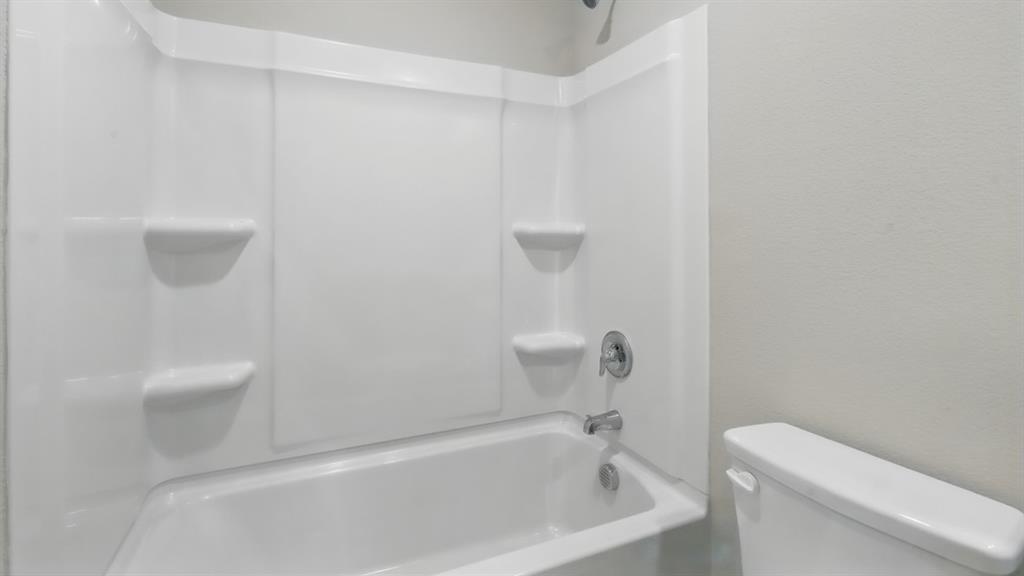 3149 Maple Orch Lane Fort Worth, TX 76140 - Photo 32 of 39 a white bath tub sitting next to a white toilet and a sink