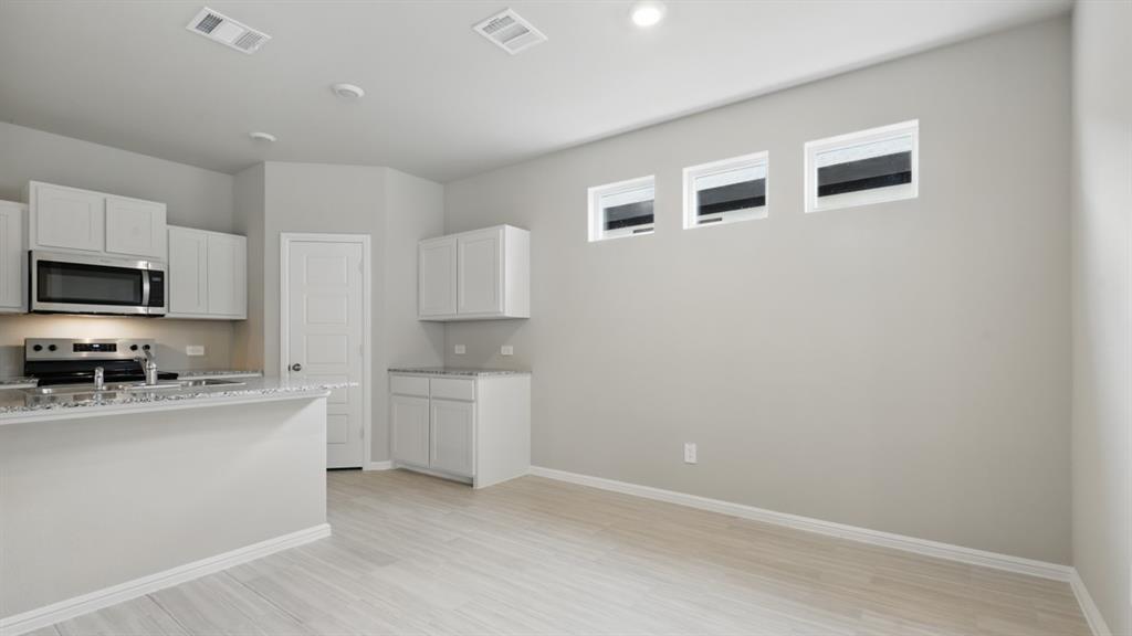 3149 Maple Orch Lane Fort Worth, TX 76140 - Photo 7 of 39 a kitchen with a sink a stove top oven and white cabinets