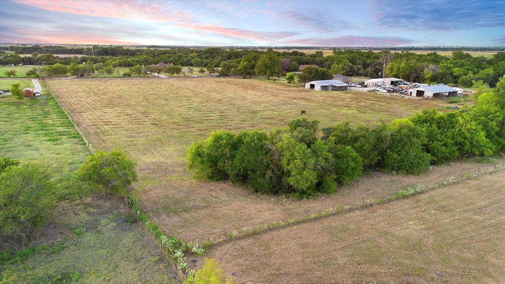 Tbd Holder Road Waxahachie, TX 75165 - Photo 11 of 24 Expansive agricultural land featuring a mix of cultivated fields and natural growth, multiple outbuildings with metal roofs, and perimeter fencing