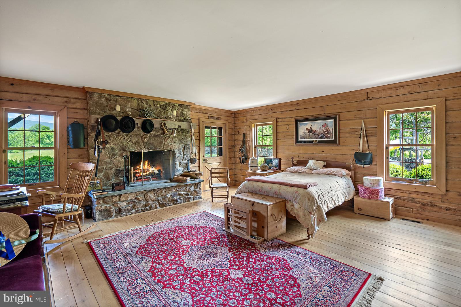 14249 Hume Road Hume, VA 22639 - Photo 23 of 48 a bedroom with a bed a flat screen tv and a fireplace