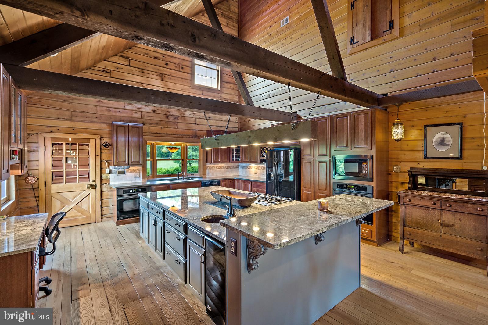 14249 Hume Road Hume, VA 22639 - Photo 9 of 48 a kitchen with stainless steel appliances granite countertop a stove and a wooden floors