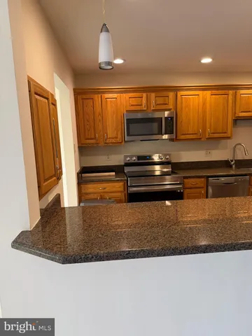a kitchen with kitchen island granite countertop a stove a sink and a granite counter top