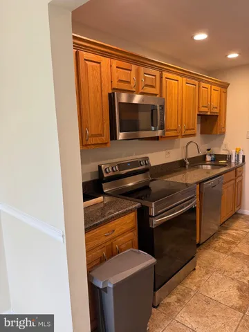 a kitchen with granite countertop a sink and a stove top oven