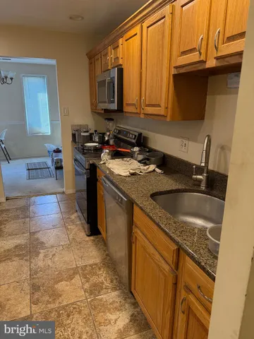 a kitchen with stainless steel appliances granite countertop a sink stove and cabinets