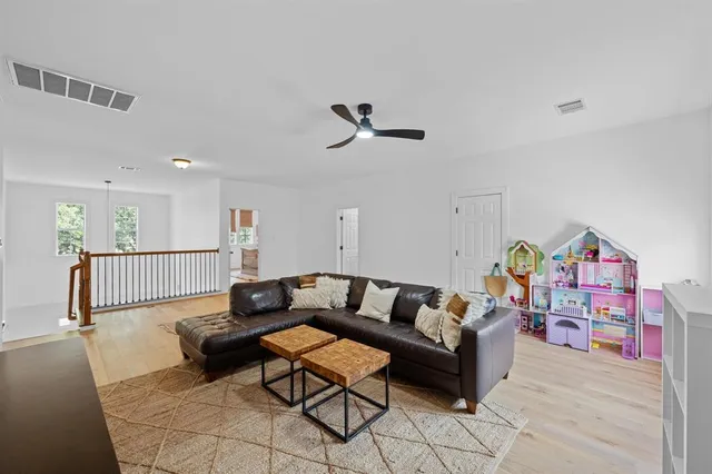 a living room with furniture and a wooden floor