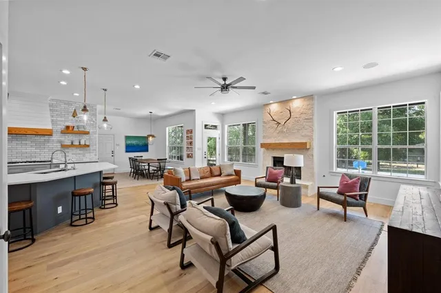 a living room with fireplace furniture and a large window