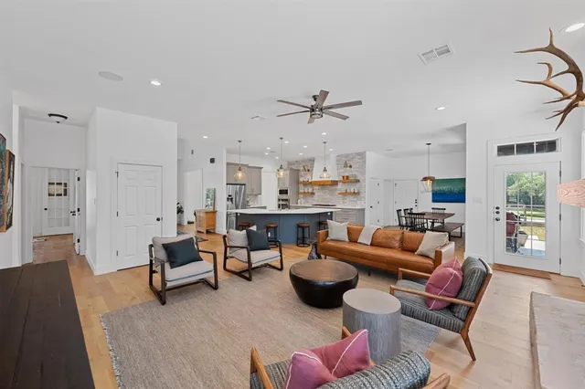 a living room with furniture kitchen view and a chandelier