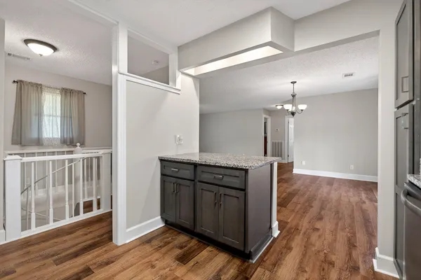 an empty room with wooden floor and staircase