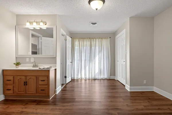 an empty room with wooden floor and cabinet